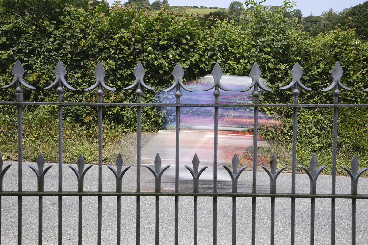 British National Road Championships 2025 - Time Trial - Elite Women - a rider speeds past the railings of a chapel