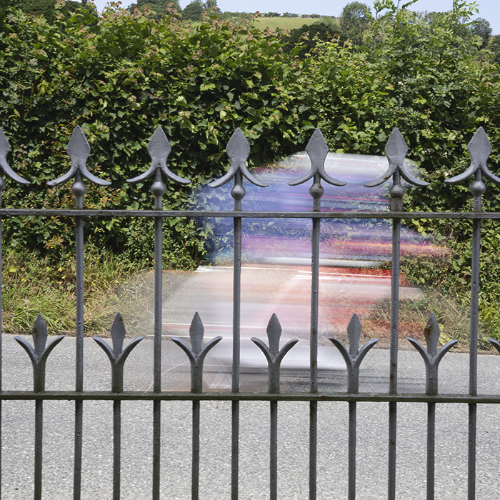 British National Road Championships 2025 - Time Trial - Elite Women - a rider speeds past the railings of a chapel