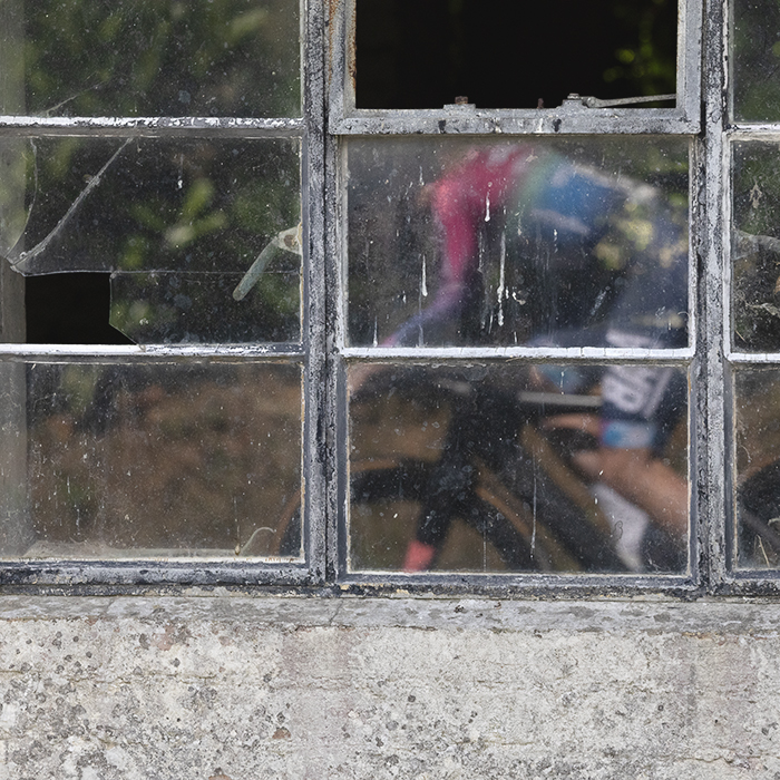 British National Road Championships 2025 - Time Trial - Elite Women - a reflection of one of the competitors in the window of a disused barn