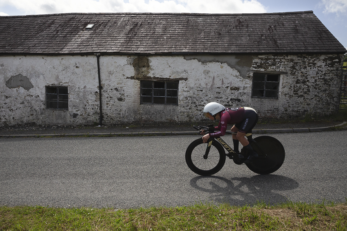 British National Road Championships 2025 - Time Trial - Elite Women - Laura Davies of FTP-Fulfil The Potential-Racing passes in front of a dilapidated barn