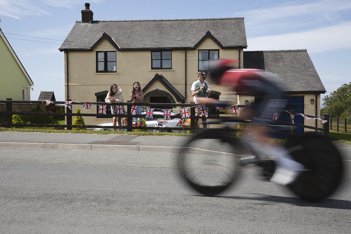 British National Road Championships 2025 - Time Trial - U23 Women - a family cheers on one of the competitors from their garden