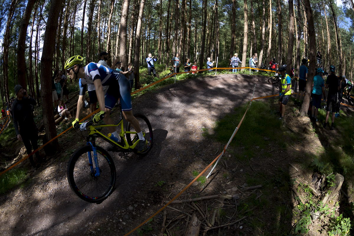 Birmingham 2022 - XXII Commonwealth Games - Mountain Bike - Men - Charlie Aldridge of Scotland is lit by patches of light through the canopy.