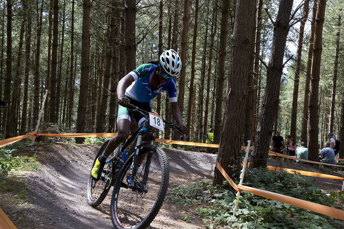 Birmingham 2022 - XXII Commonwealth Games - Mountain Bike - Men - Phetetso Monese of Lesotho on a berm with trees behind him