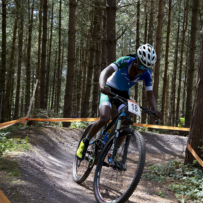 Birmingham 2022 - XXII Commonwealth Games - Mountain Bike - Men - Phetetso Monese of Lesotho on a berm with trees behind him