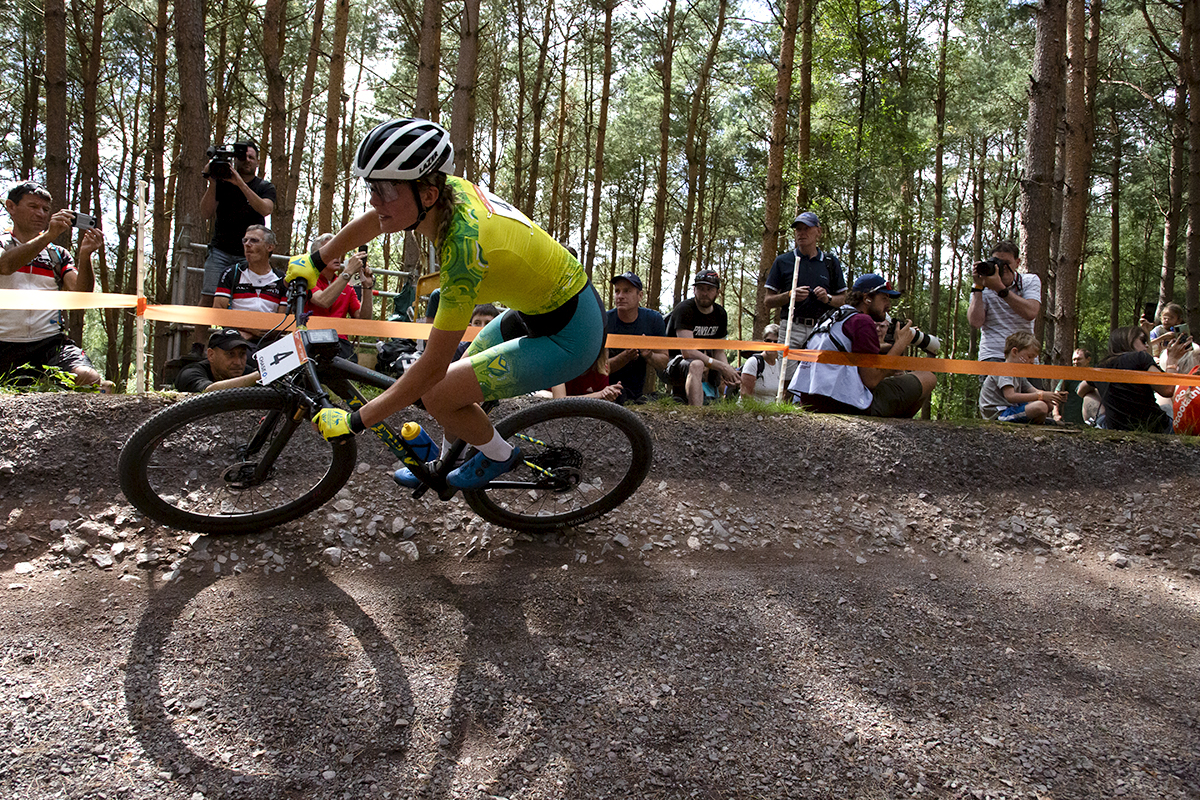 Birmingham 2022 - XXII Commonwealth Games - Mountain Bike - Women - The shadow of Zoe Cuthbert’s bike is visible as the Australian races through the forest