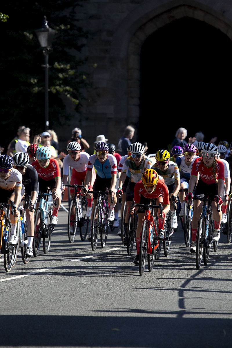 Birmingham 2022 - XXII Commonwealth Games - Women’s Road Race - The peloton races away from a medieval city gate