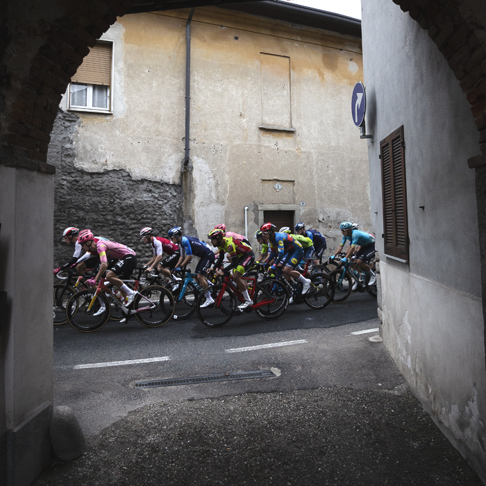 Coppa Bernocchi 2024 - The peloton seen through an archway in Castelseprio