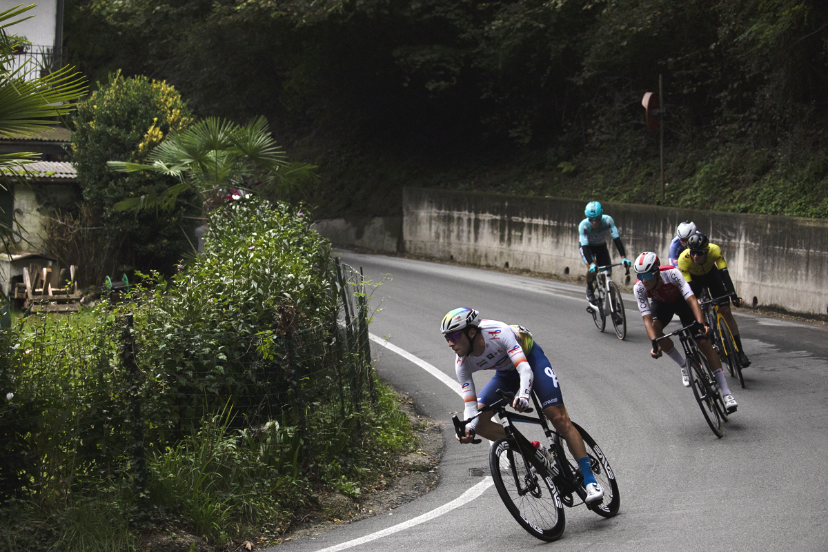 Coppa Bernocchi 2024 - Riders take on a sharp bend near a lush garden in Castelseprio