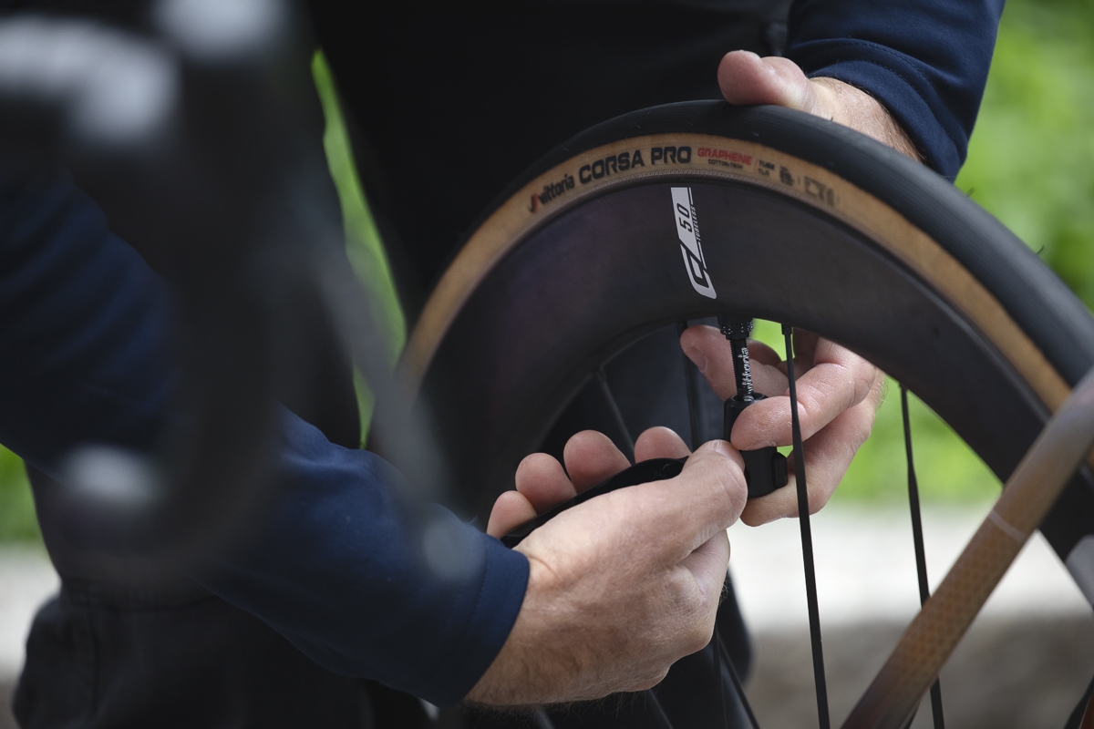 Coppa Bernocchi 2024 - A mechanic from Team Jayco AlUla checks tyre pressure before the start of the race