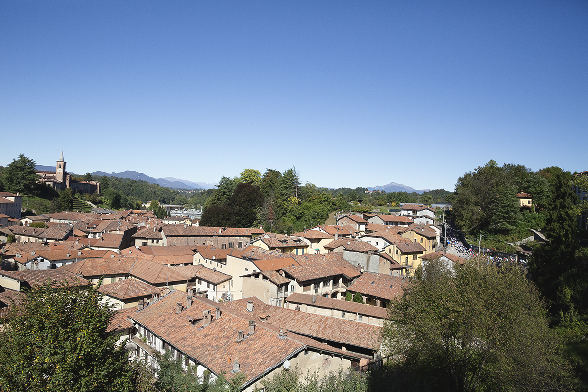 Coppa Bernocchi 2025 - The race can be seen rounding a bend in the distance with the rooftops of Castiglione Olona in the foreground
