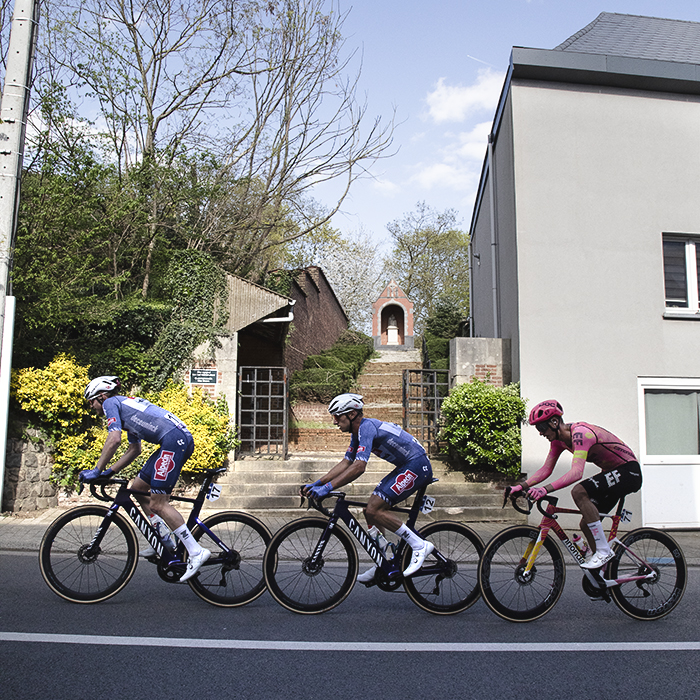 De Brabantse Pijl 2024 - A group of three riders pass a shrine in Overijse