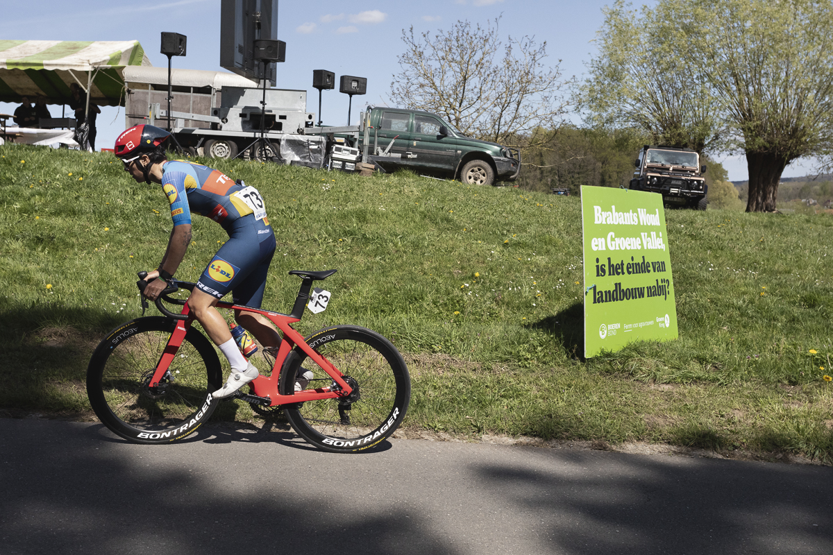 De Brabantse Pijl Vrouwen 2024 - Ilaria Sanguineti passes a sign near a farmer’s protest that reads Brabants Woud en Groene Vallei, is het einde van landbouw nabij? Brabants Forest and Green Valley, is the end of agriculture near?
