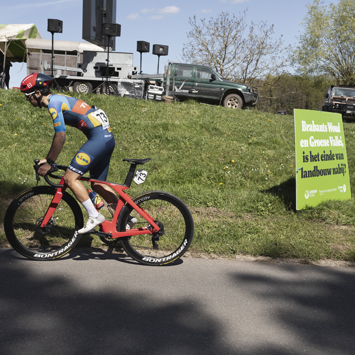 De Brabantse Pijl Vrouwen 2024 - Ilaria Sanguineti passes a sign near a farmer’s protest that reads Brabants Woud en Groene Vallei, is het einde van landbouw nabij? Brabants Forest and Green Valley, is the end of agriculture near?