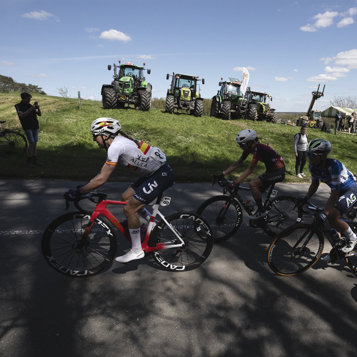 De Brabantse Pijl Vrouwen 2024 - Mavi García of Liv AlUla Jayco wears the Spanish Champion’s jersey as she passes a line of tractors while protesting farmers watch the race
