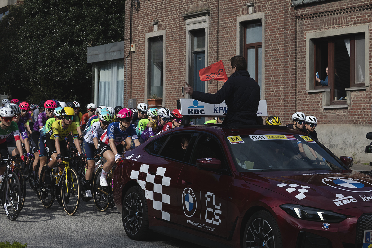 De Brabantse Pijl Vrouwen 2025 - The Race Director appears out of the sunroof of his car, flag in hand, preparing to start the race