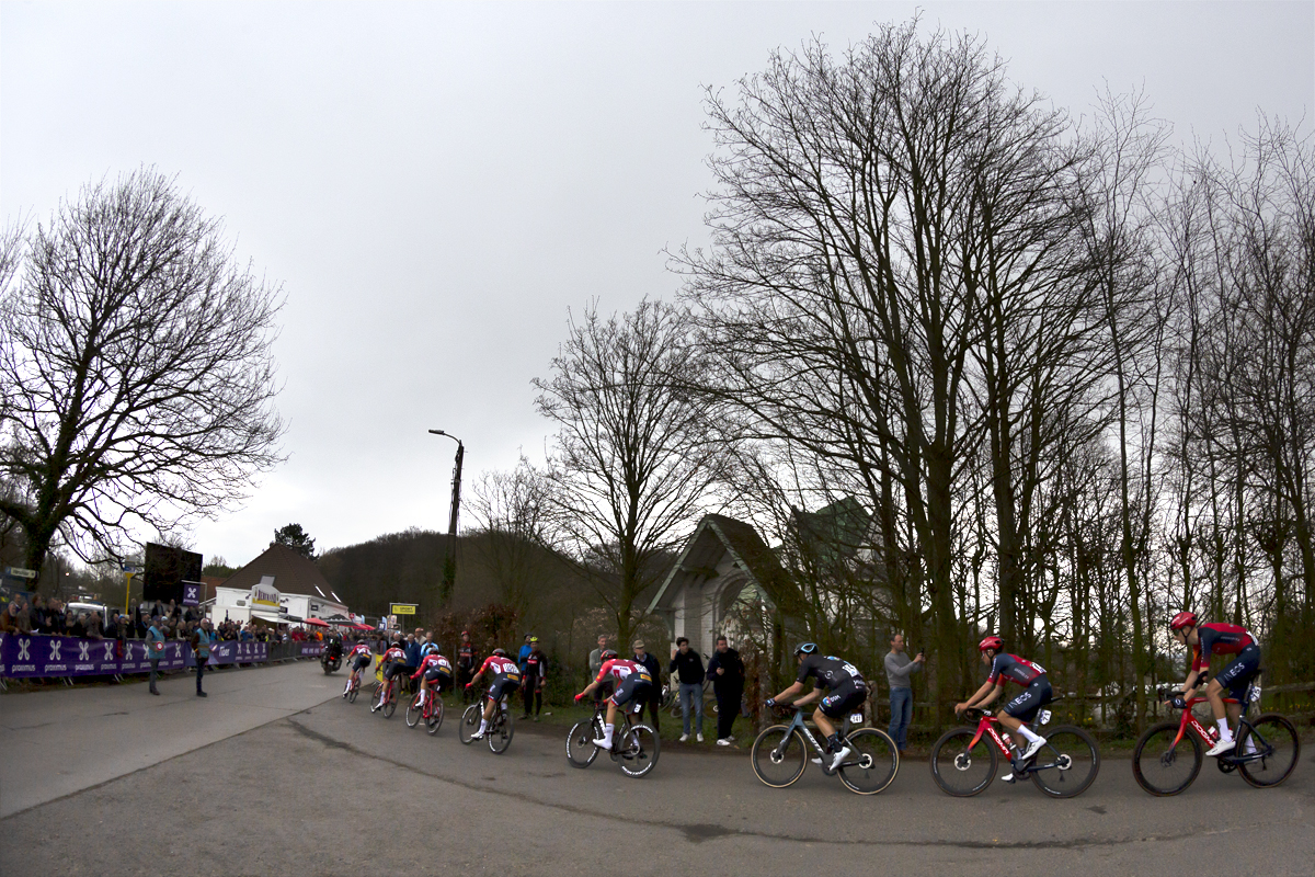 Dwars Door Vlaanderen 2023 - The race going passes a roadside shrine