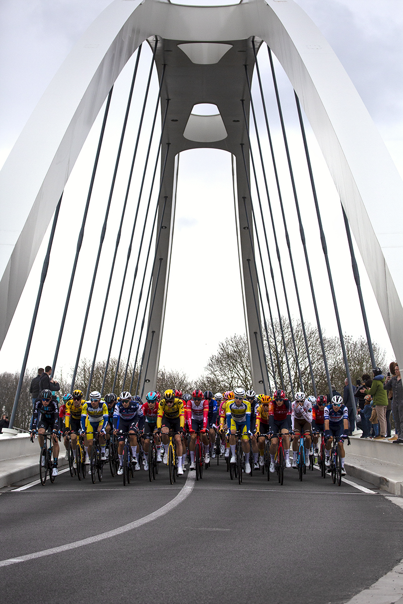 Dwars Door Vlaanderen 2023 - The peloton crossing the Munkenbrug bridge