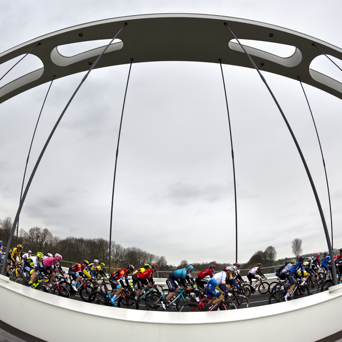 Dwars Door Vlaanderen 2023 - The peloton seen from the side crossing the Munkenbrug