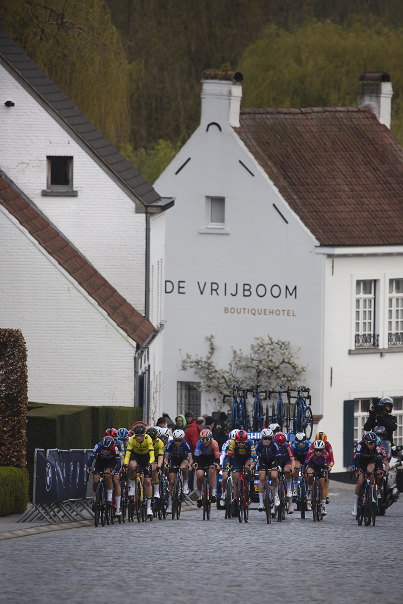 Dwars Door Vlaanderen Vrouwen 2024 - The women’s race seen against the white washed buildings of Nokere