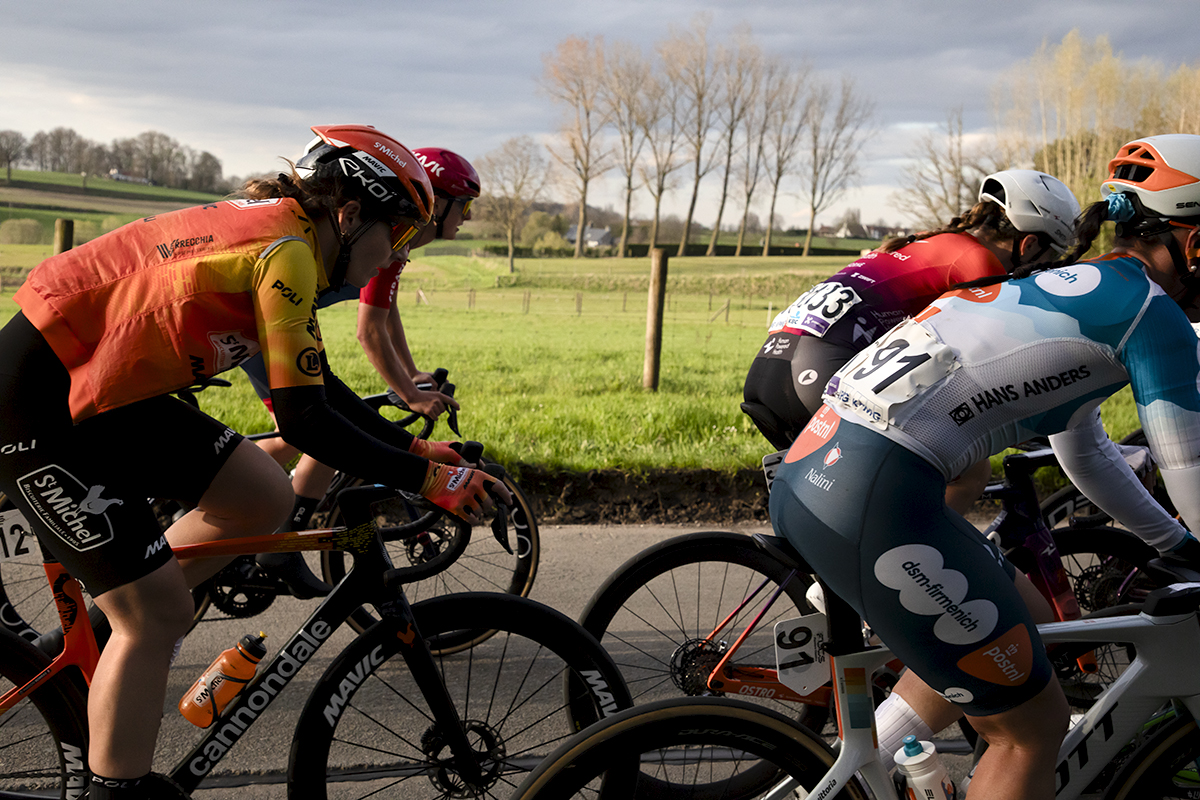 Dwars Door Vlaanderen Vrouwen 2024 - Riders form a frame for a view of the Belgian countryside