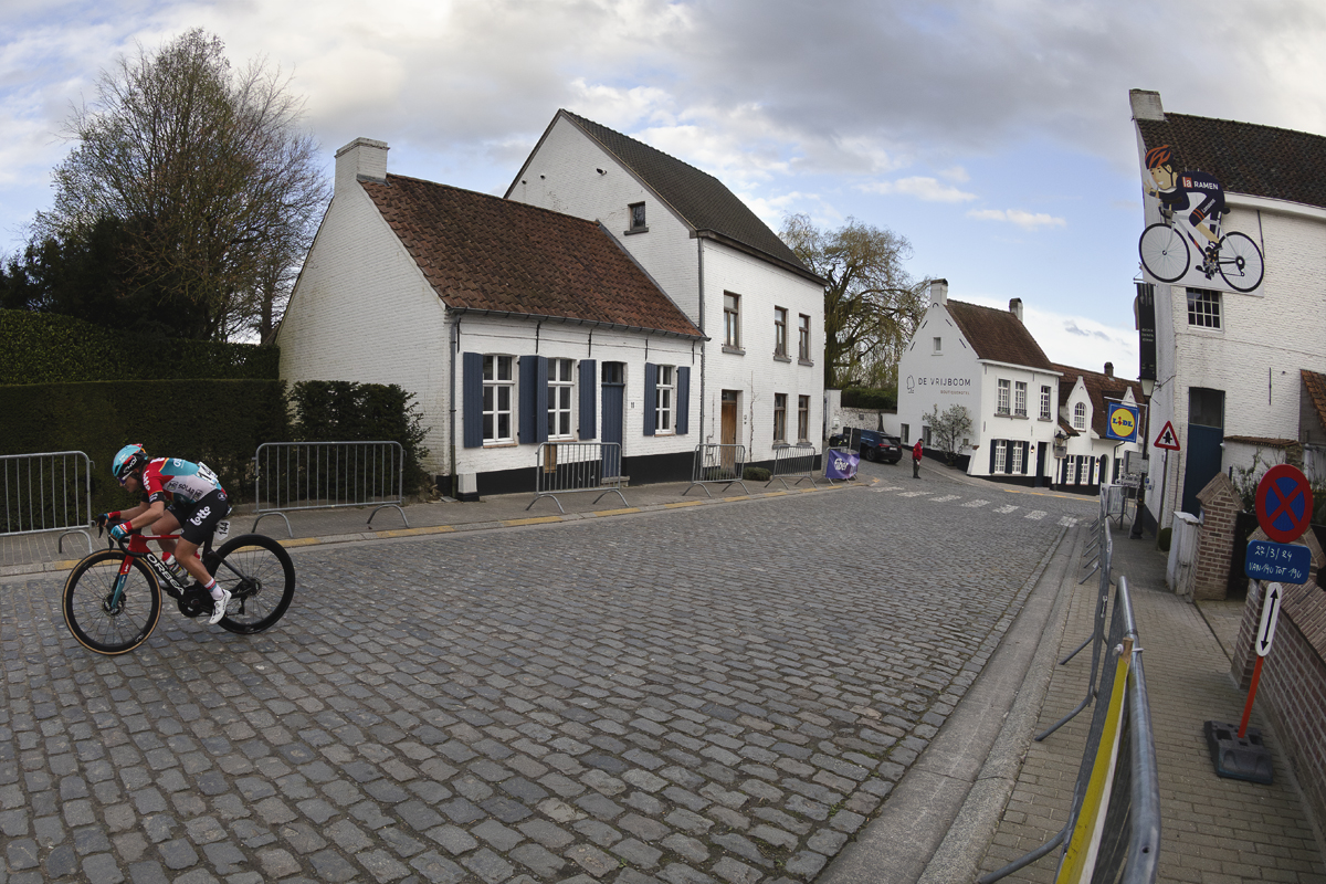 Dwars Door Vlaanderen Vrouwen 2024 - Audrey De Keersmaeker races on the cobbles with white washed buildings behind