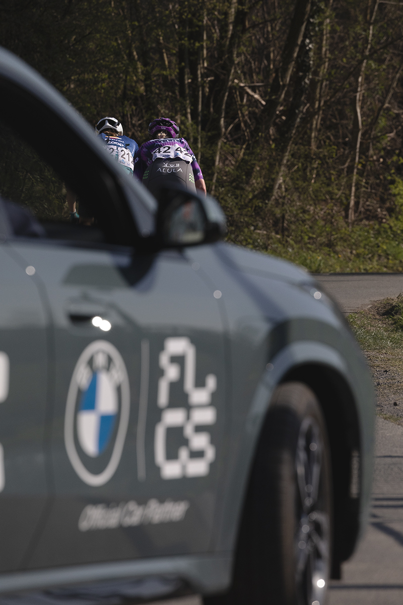 Dwars Door Vlaanderen  Vrouwen 2025 - Stina Kagevi and Amber Pate seen from behind framed by a race vehicle