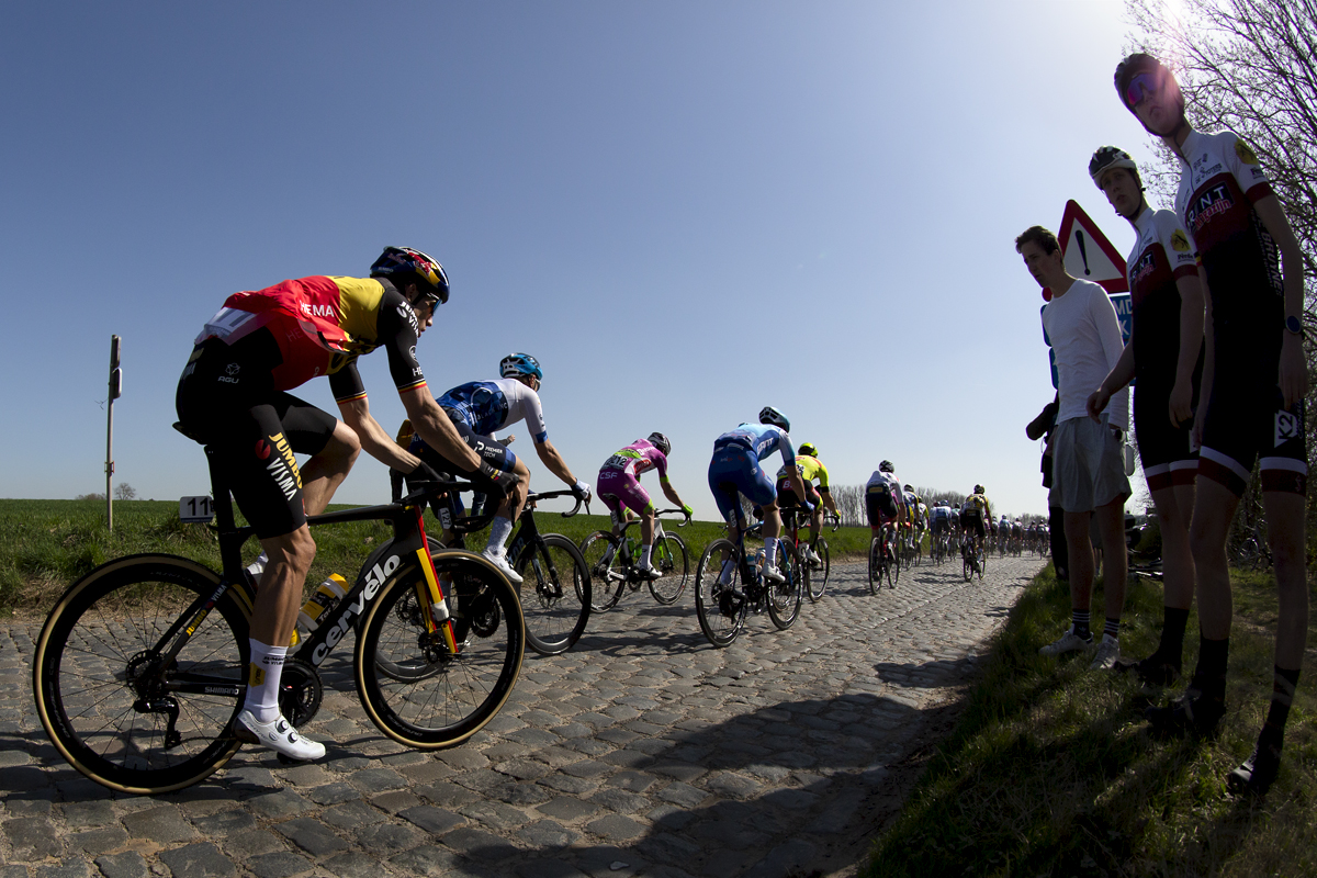 E3 Saxo Bank Classic 2022 - Supporters at the side of the road take in the action as Wout van Aert of Jumbo-Visma passes wearing the Belgium Champions jersey