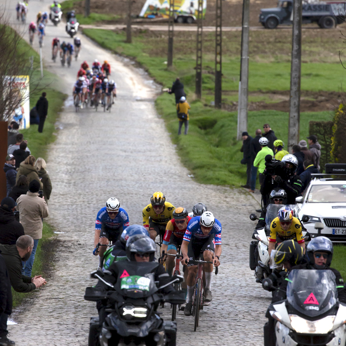 E3 Saxo Classic 2023 - An elite breakaway group makes its way up the cobbles preceded by motorbikes