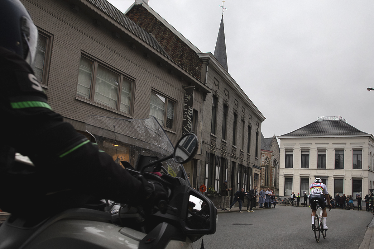 E3 Saxo Classic 2024 - Mathieu van der Poel seen from behind as he races solo through the streets of Kluisbergen