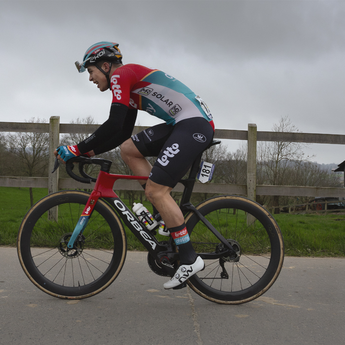 E3 Saxo Classic 2024 - Arnaud De Lie passes in front of a field and farm buildings