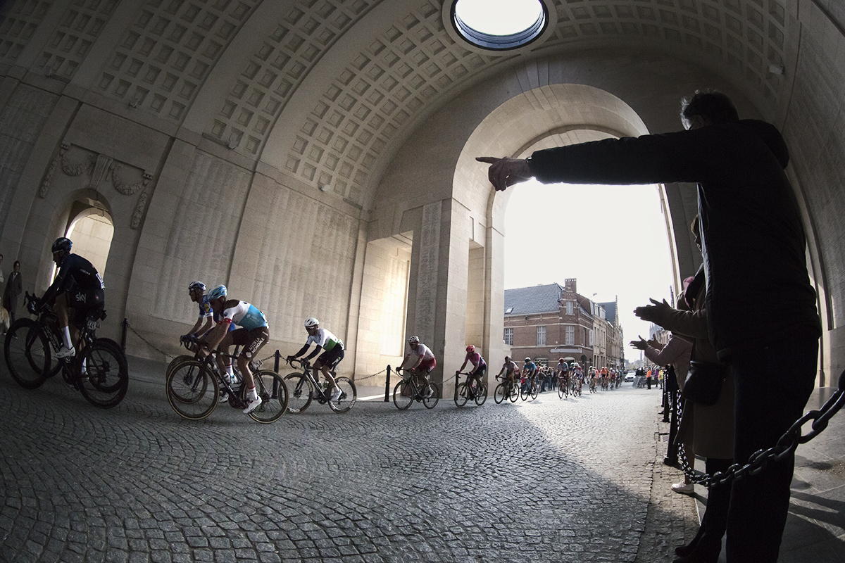 Gent Wevelgem 2019 - a fan points as the peloton passes through the Menin Gate in Ieper / Ypres