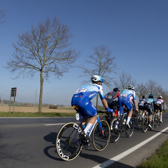 Gent - Wevelgem 2022 - The rear of a group of riders on an exposed rural road