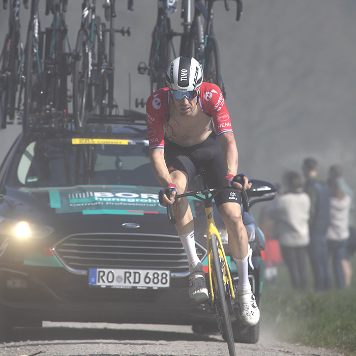 Gent - Wevelgem 2022 - Timo Roosen of Jumbo-Visma with his shirt undone followed closely by a Bora team car on a Ploegsteert