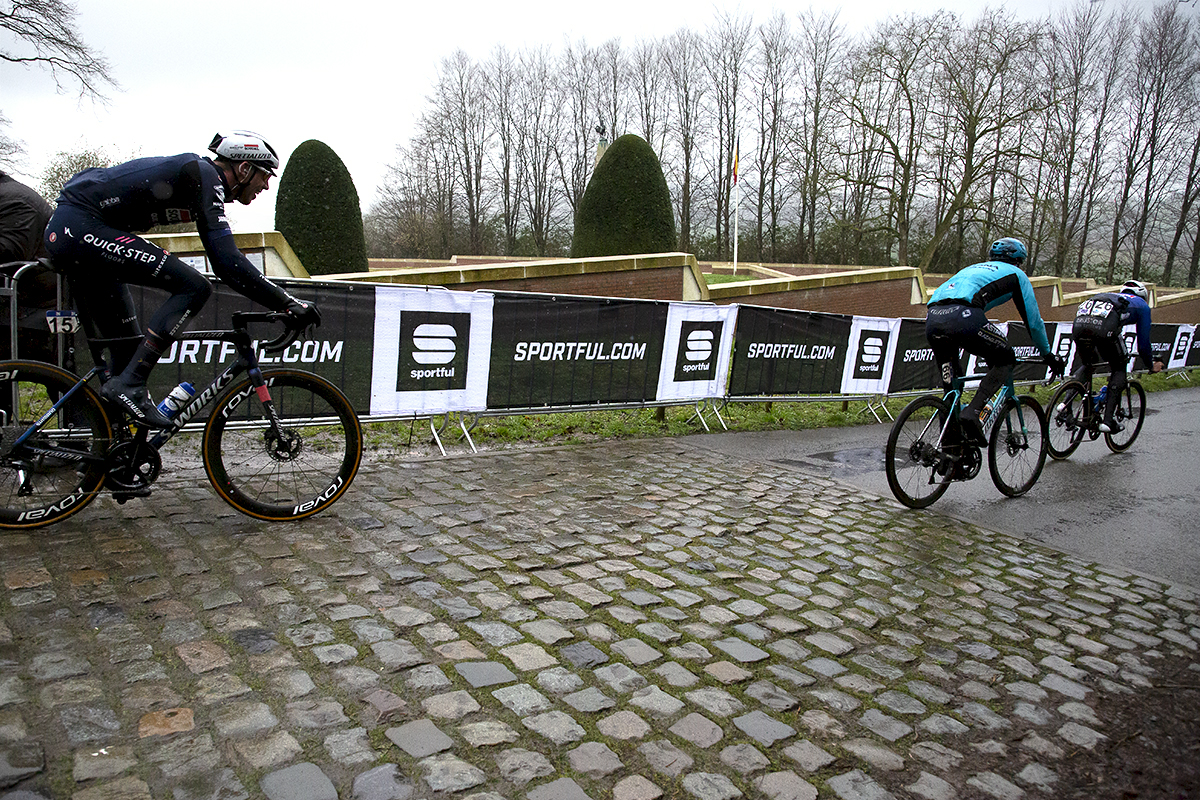 Gent - Wevelgem 2023 - A group of riders descends the Kemmelberg past the Ossuaire monument