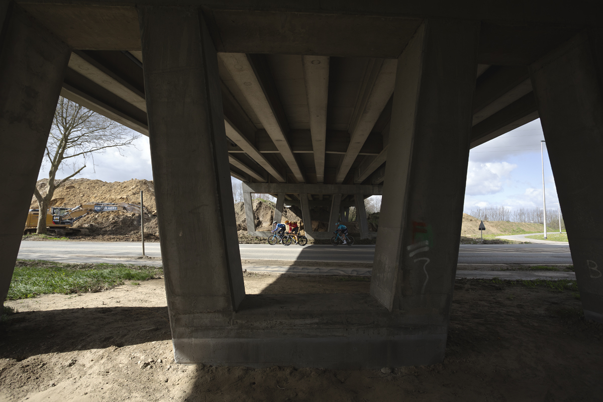 Gent Wevelgem 2024 - Riders pass under a modern bridge in Morsele