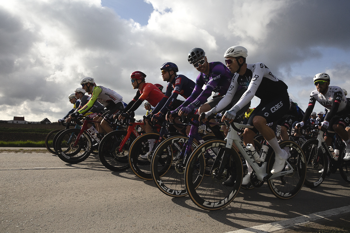 Gent Wevelgem 2025 - A line of riders at the front of the race as it rolls out through Potyze