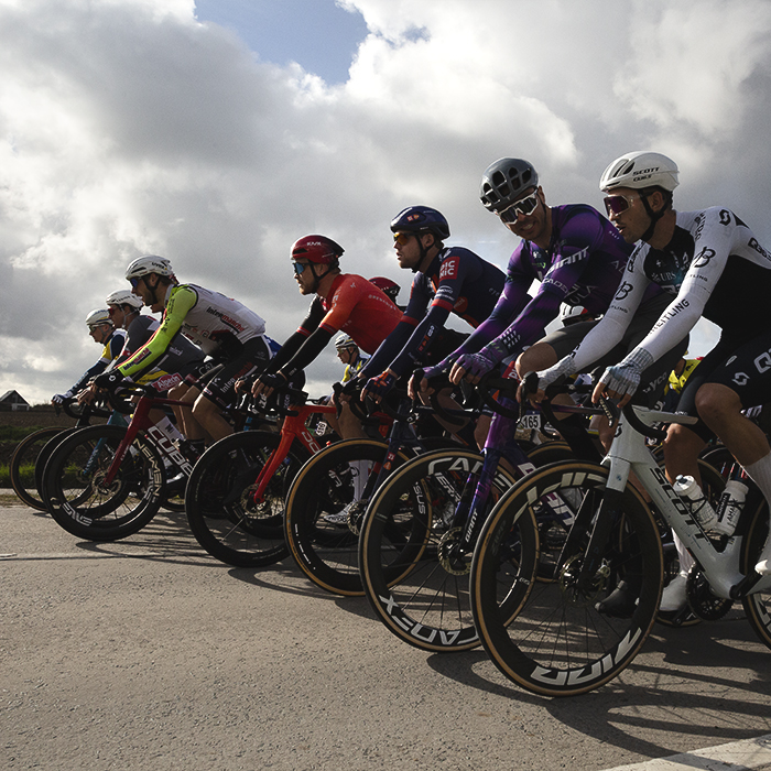 Gent Wevelgem 2025 - A line of riders at the front of the race as it rolls out through Potyze