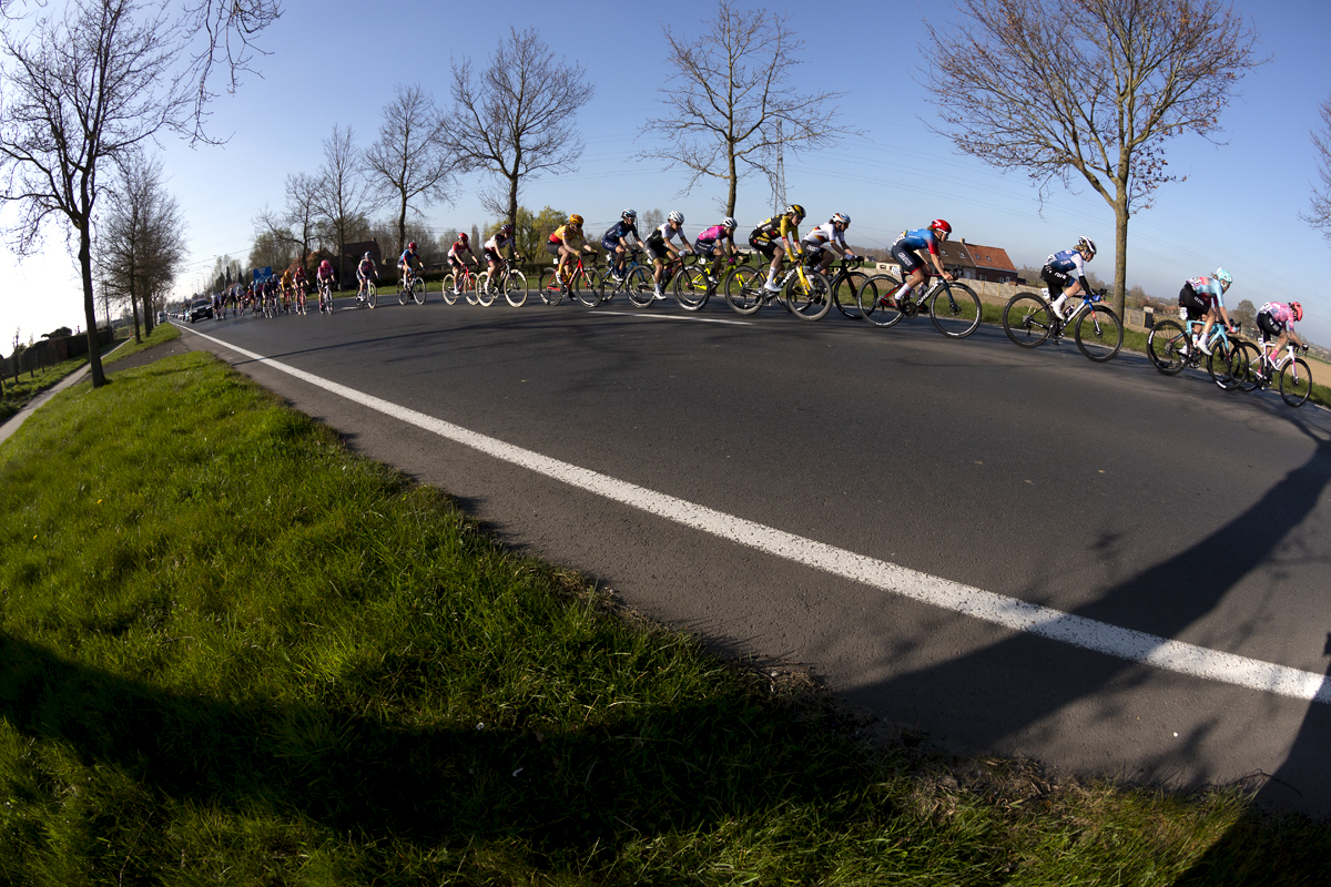 Gent - Wevelgem Vrouwen 2022 - The peloton ride down a straight through the flat farmland of the Belgium countryside