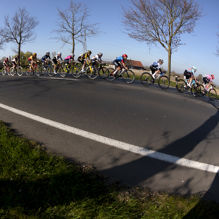 Gent - Wevelgem Vrouwen 2022 - The peloton ride down a straight through the flat farmland of the Belgium countryside