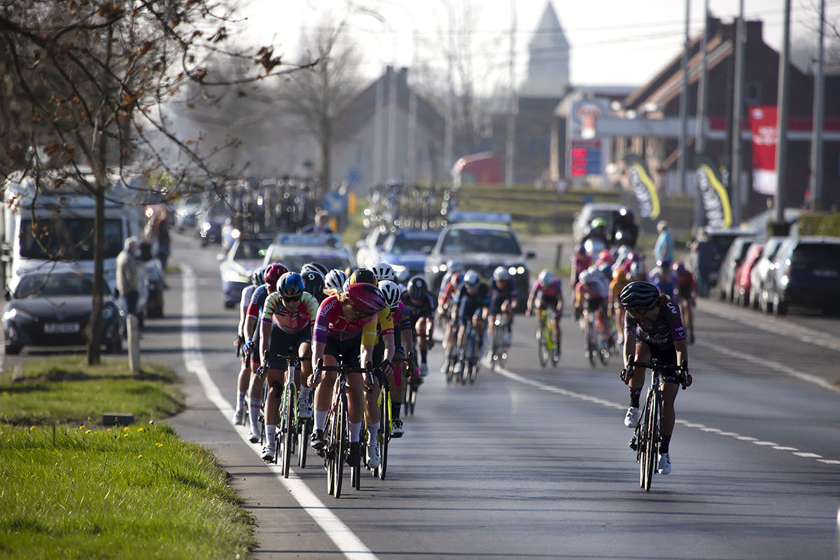 Gent - Wevelgem Vrouwen 2022 - The peloton with a church in the background