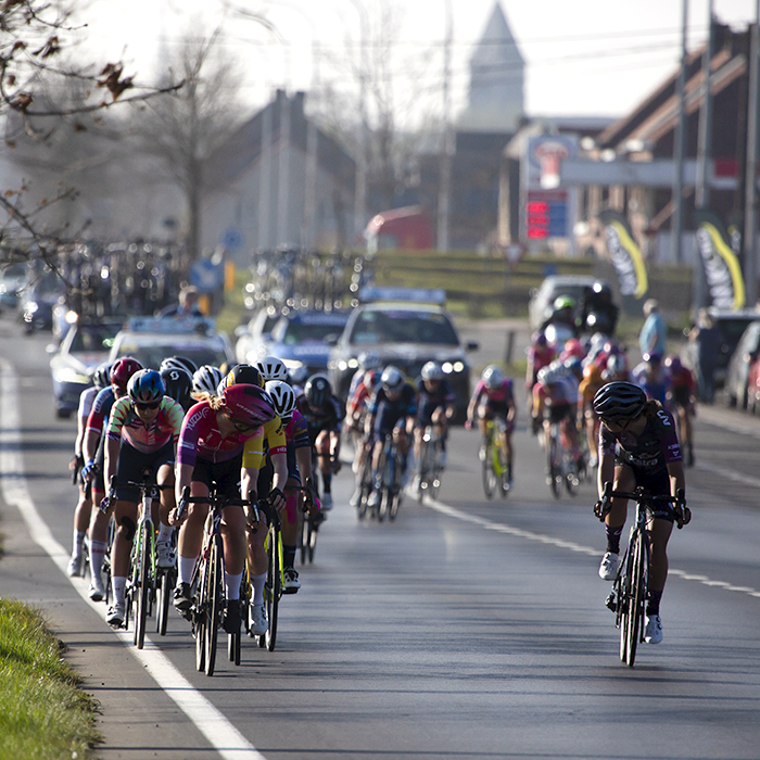 Gent - Wevelgem Vrouwen 2022 - The peloton with a church in the background