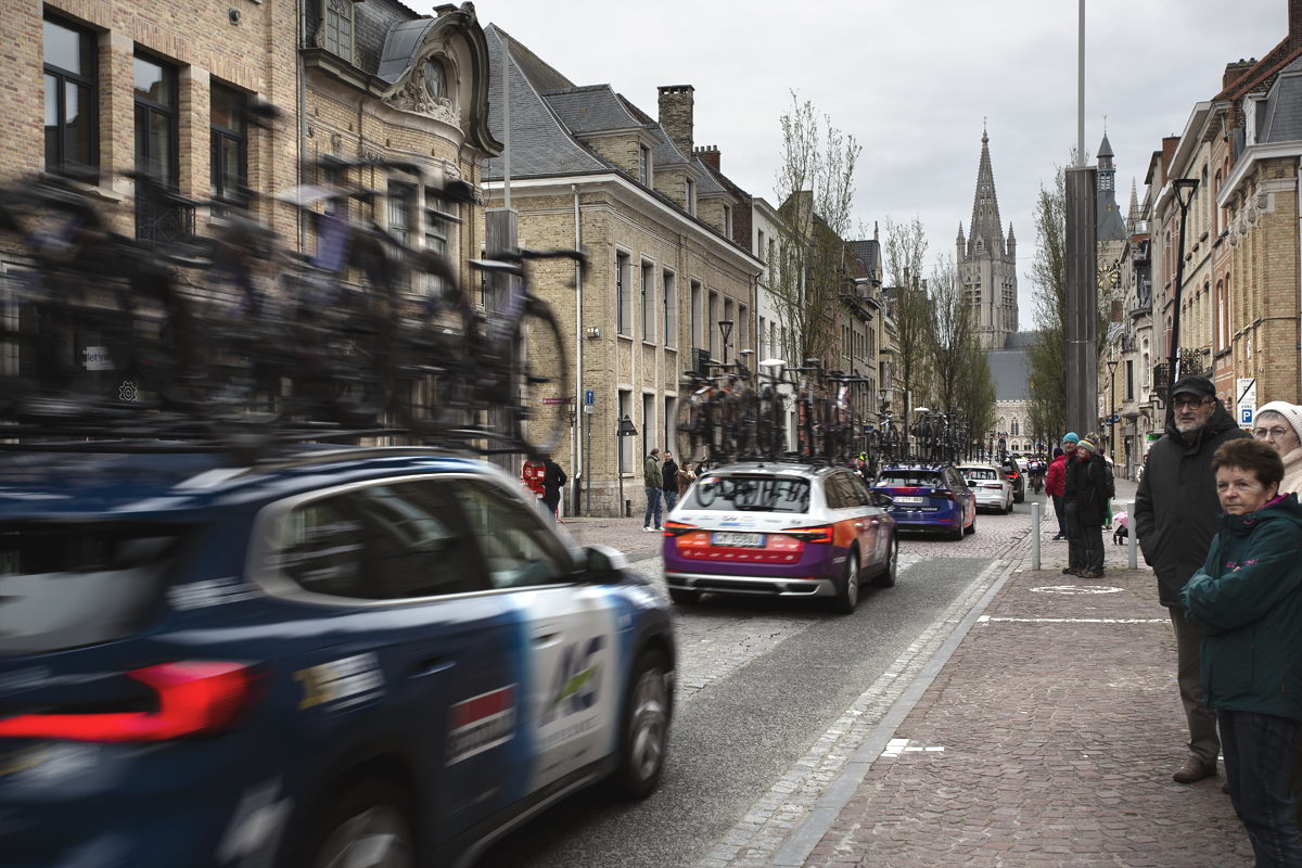 Gent Wevelgem Vrouwen 2024 - Team cars speed past spectators in the historic centre of Ieper / Ypres