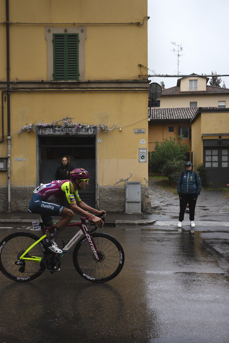 Giro dell’Emilia 2024 - Roberto Carlos Gonzalez of Team Corratec - Vini Fantini passes a yellow building watched by drenched fans