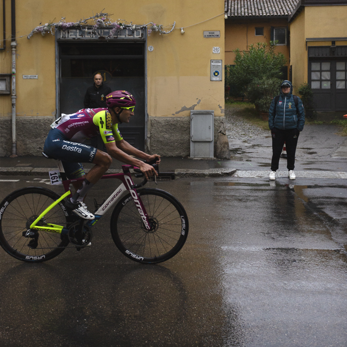 Giro dell’Emilia 2024 - Roberto Carlos Gonzalez of Team Corratec - Vini Fantini passes a yellow building watched by drenched fans