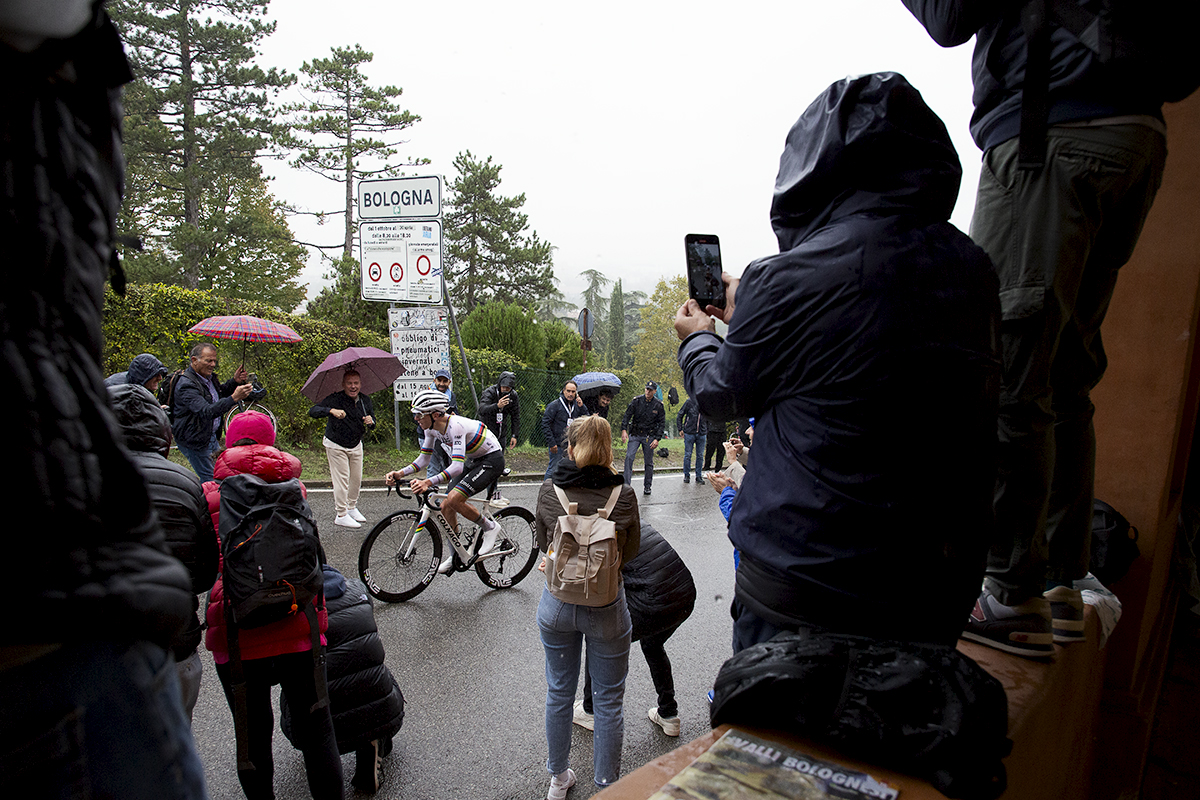 Giro dell’Emilia 2024 - Tadej Pogačar is cheered on by fans holding umbrellas on the way up the Via di San Luca