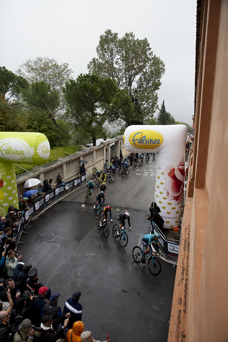 Giro dell’Emilia 2024 - Riders viewed from above pass by inflatable advertising arches as they take a corner on Via di San Luca