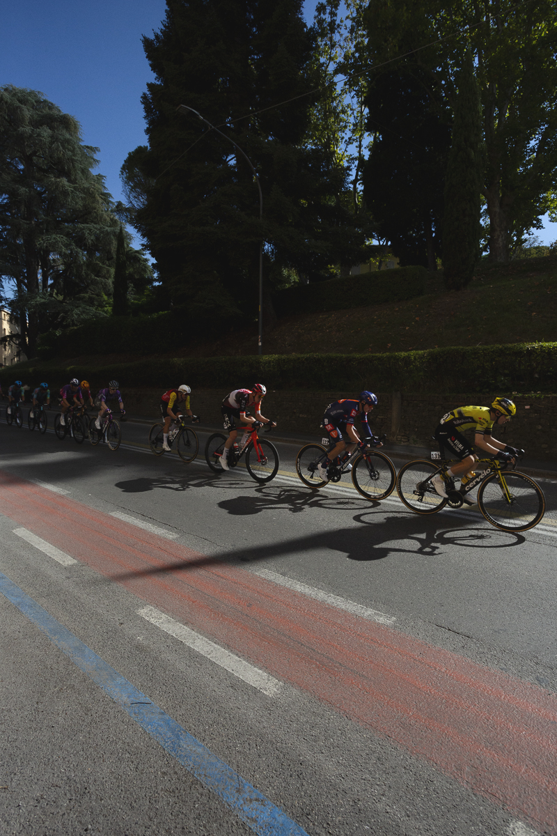 Giro dell’Emilia 2025 - Riders cast long shadows on the road in Bologna