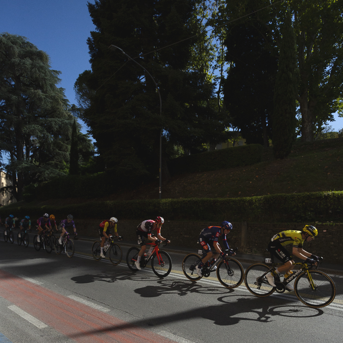 Giro dell’Emilia 2025 - Riders cast long shadows on the road in Bologna