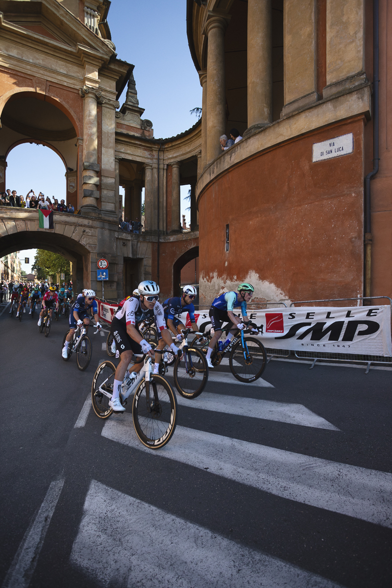 Giro dell’Emilia 2025 - The race passes under the Arco del Meloncello on the start of the San Luca climb