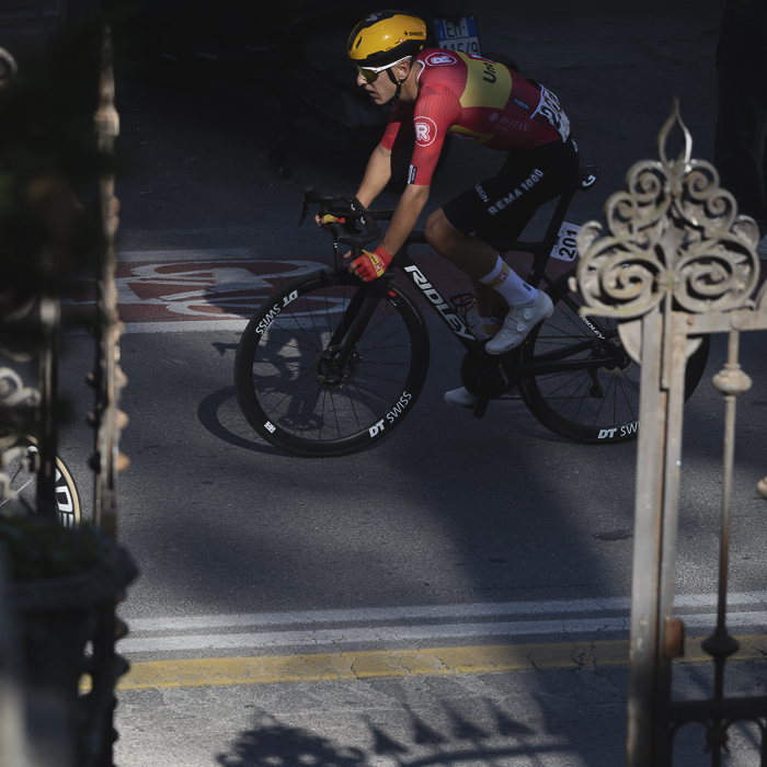 Giro dell’Emilia 2025 - Tobias Halland Johannessen passes by ornate gates in Bologna